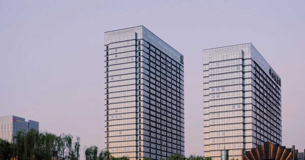 Glass office towers reflecting an evening sky, the corporate landscape agentic AI companies now compete across