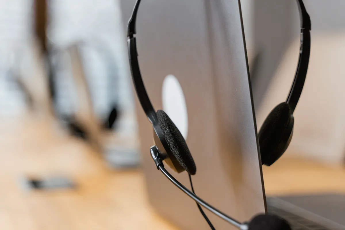 A headset resting on a laptop keyboard, the setup AI voice agent services for businesses aim to automate