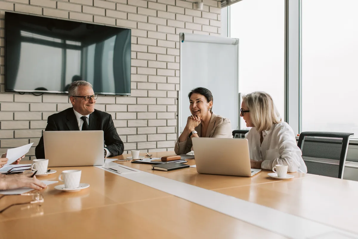 Executives around a meeting table reviewing documents, the kind of board discussion behind AI governance news on incidents