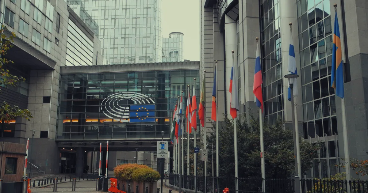 European Parliament building in Brussels with EU member state flags, the backdrop to October AI governance news