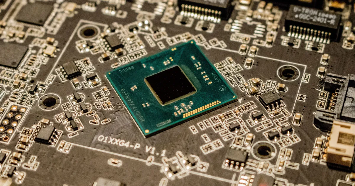 Close-up of a microchip on a green circuit board, illustrating AI hardware news on chips and memory