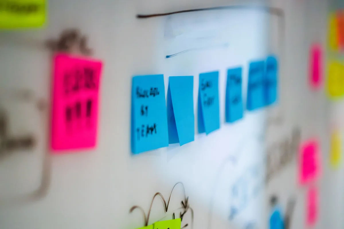 Sticky notes arranged on a whiteboard during a planning session, the kind of decision mapping that AI governance needs