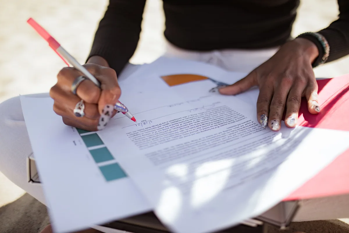 A hand editing a printed page with a red pen, the review step that decides whether a task suits generative AI