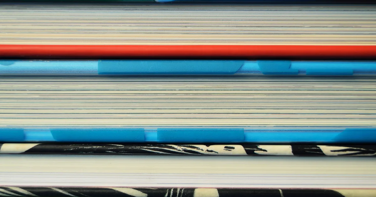 Close-up of stacked book edges in coloured bands, standing in for a ranking of the best AI engineering books in 2026