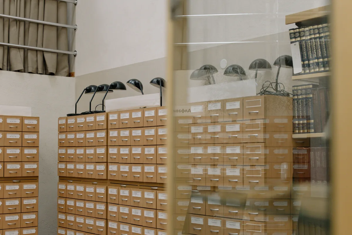 A vintage library card catalog with brass label holders, the filing discipline a prompt library borrows