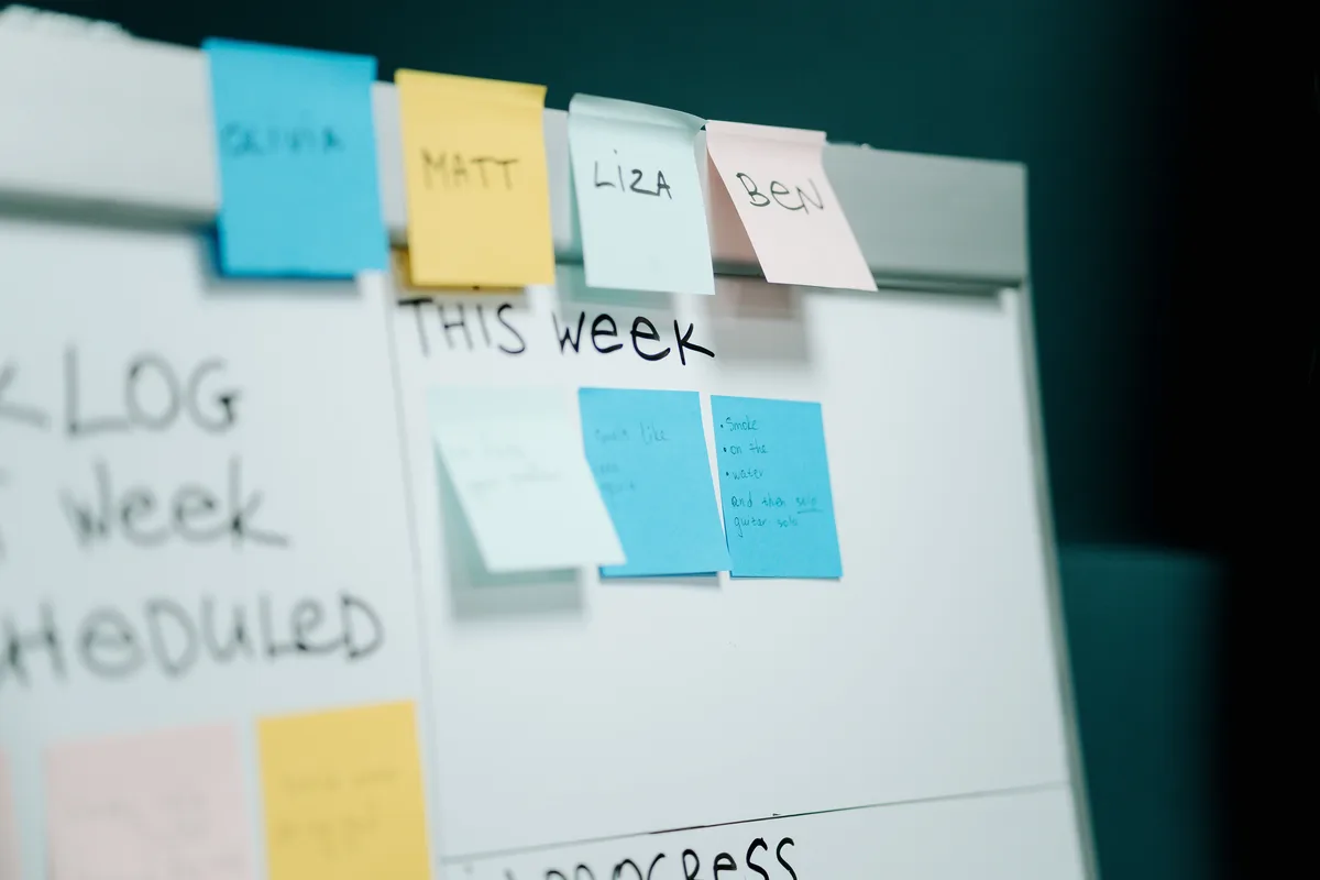 Whiteboard covered in sticky notes during a problem-definition session for an AI agent build