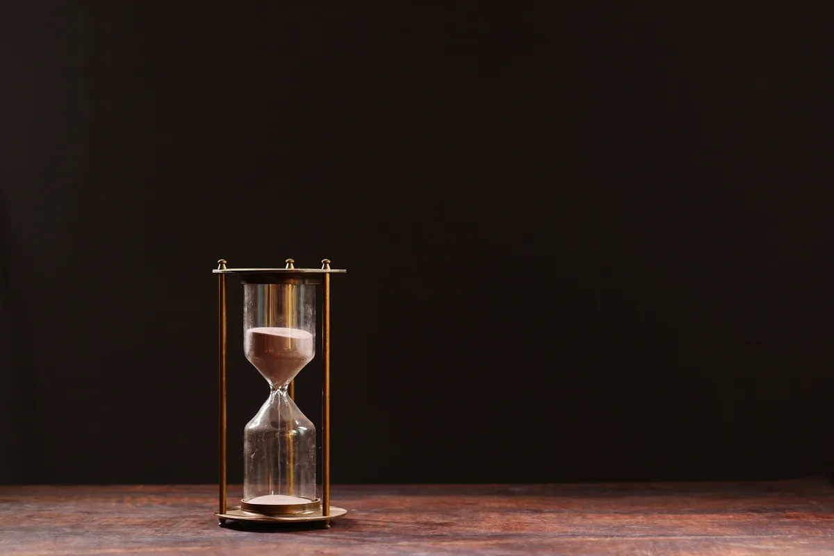 A classic hourglass with sand trickling down against a dark background, standing in for the five-hour session window in Claude AI usage limits