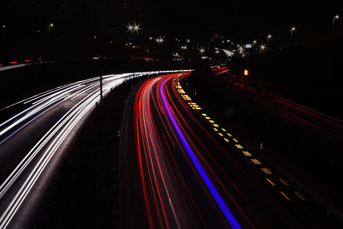 Long exposure of car light trails on a highway at night, the streaked motion blur that speed prompts ask Grok Imagine to reproduce