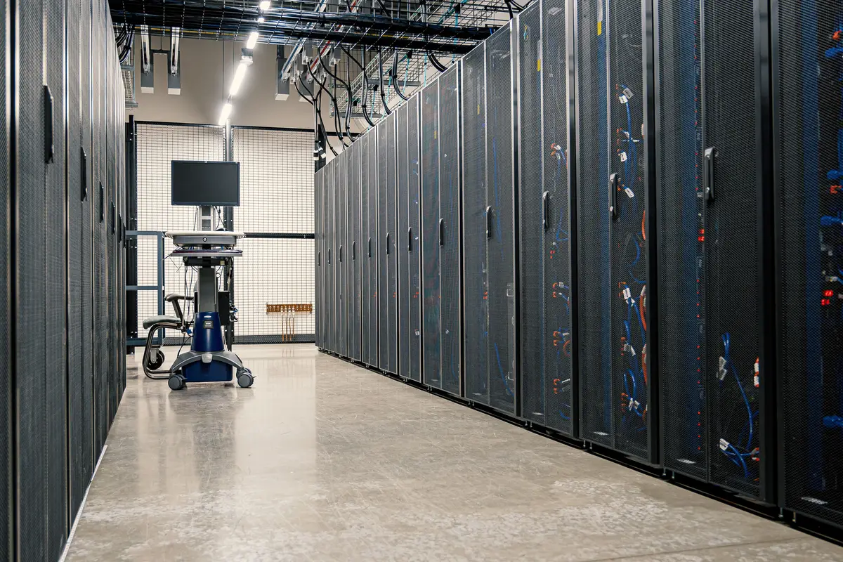 Rows of server racks and network cabling in a data centre, the kind of hardware where the LLM behind ChatGPT runs
