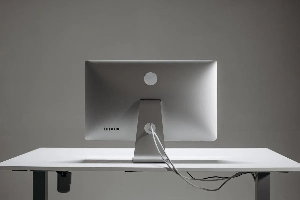 A silver Mac mini on a white desk, a small machine that can run a local LLM from unified memory