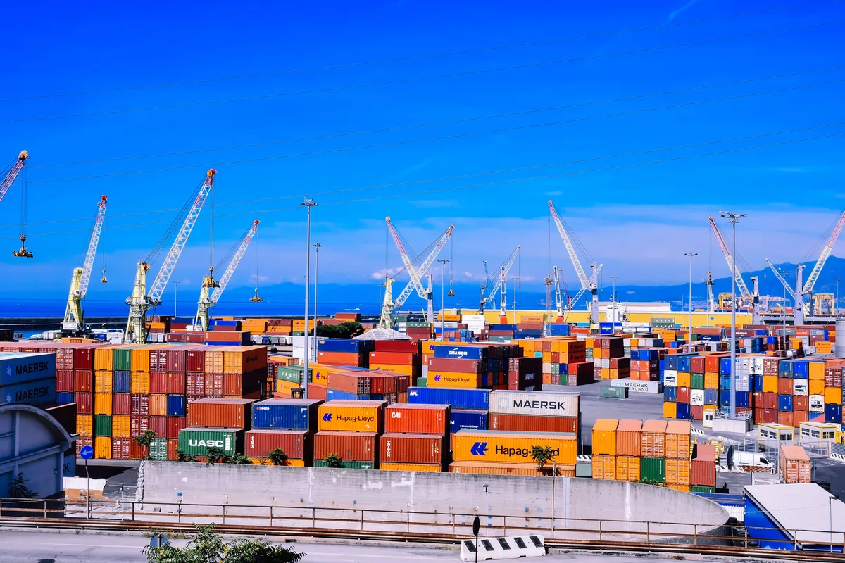 Container port with stacked cargo and cranes, the shipping layer of the AI hardware supply chain